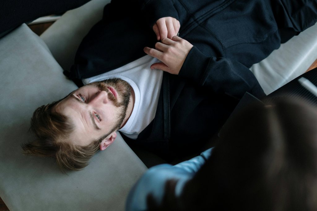 Man lying on a couch during a therapy session, illustrating how men’s therapy in Colorado Springs, CO supports mental health and emotional healing.