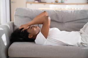 A girl lays in bed feeling overwhelmed. This demonstrates concepts of childhood emotional neglect in Colorado Springs, CO. Our therapists can help with anxiety, depression, and trauma.