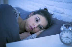 A woman mays in bed with a blank stare on her face. This could represent the discomfort of anxiety in Colorado Springs, CO. Contact an anxiety therapist in Colorado Springs, CO for info on anxiety treatment in Colorado Springs, CO. Anxiety counseling can support you in overcoming your fears!