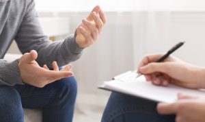 A clients hand's gesture as the person across from them writes on their clipboard. This could represent anxiety treatment in Colorado Springs, CO. Contact an anxiety therapist for more info on anxiety therapy and our other services!