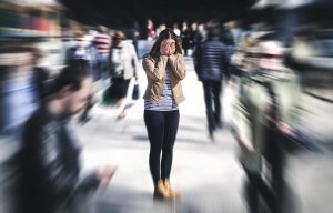 A woman covers her face in a crowd as people walk around her. This could represent the pain of anxiety. We offer anxiety treatment in Colorado Springs, CO. Contact an anxiety therapist for more info on anxiety counseling and how we can support you! In addition, we offer online therapy in Colorado. 
