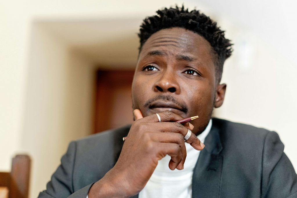 Man sitting with hand on chin and a thoughtful expression, reflecting internal stress, emotional processing, and men’s therapy for stress in Colorado Springs, CO.