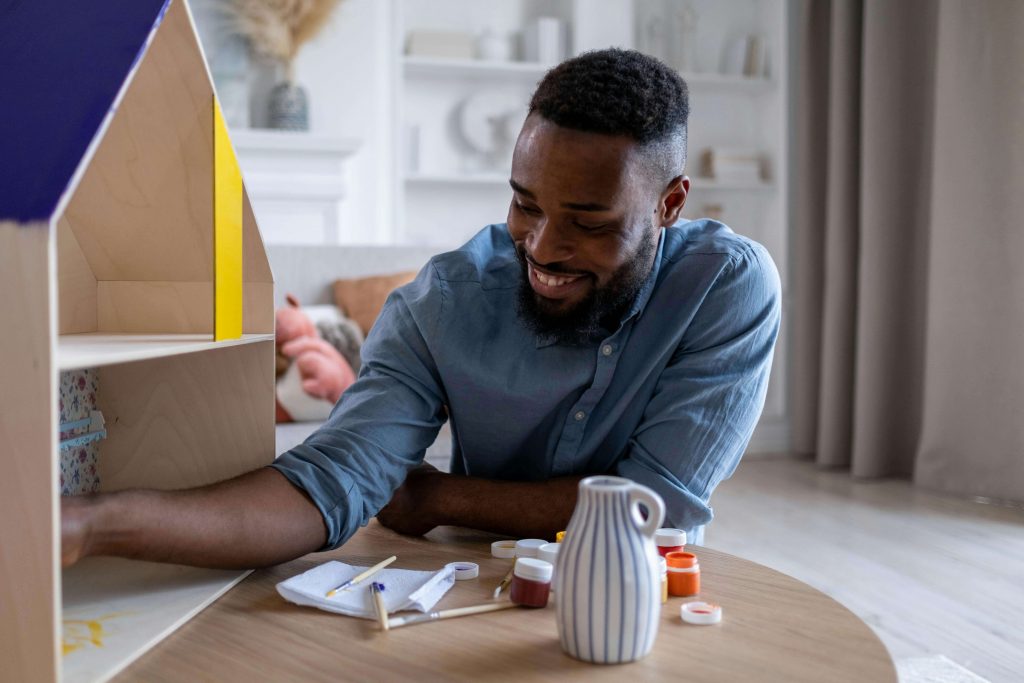Man focused on a quiet creative activity at home, showing how grief can surface through solitude and reflection in grief counseling for men in Colorado Springs, CO.