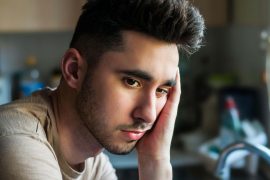 Man looking sad and deep in thought, representing emotional processing supported by therapy for breakups in Colorado Springs, CO.