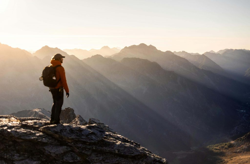 Man standing near mountains looking hopeful, symbolizing growth and emotional adjustment through therapy for breakups in Colorado Springs, CO.
