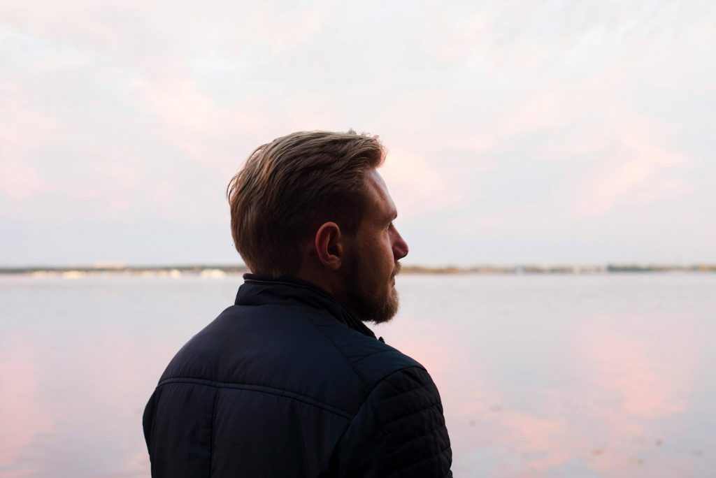 Man looking into the distance thoughtfully, representing exploration of masculinity and mental health in Colorado Springs, CO.