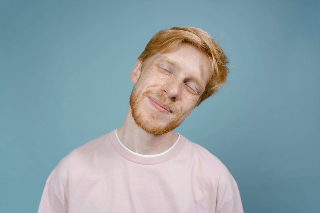 Man smiling with eyes closed in a content expression, symbolizing healing and growth through masculinity and mental health in Colorado Springs, CO.