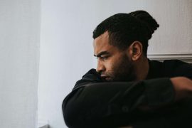 Man looking off to the side deep in thought, illustrating emotional disconnection explored in men’s therapy for emotional withdrawal in Colorado Springs, CO.