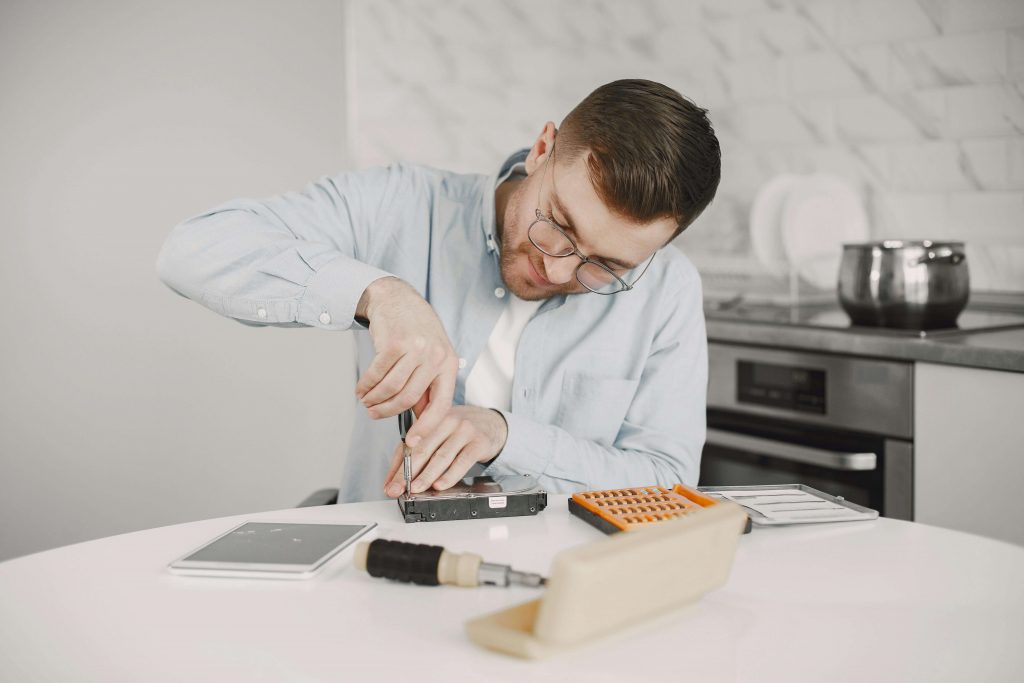 Man using tools to repair a device, representing perfectionism and control patterns explored in therapy for perfectionistic men in Colorado Springs, CO.