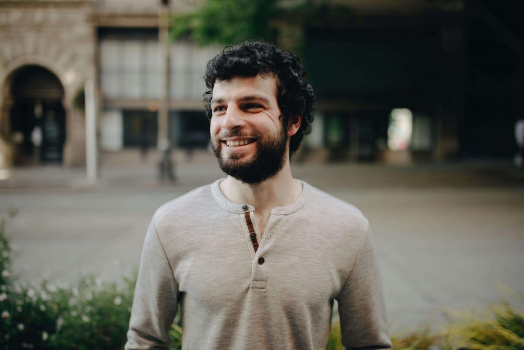 Man smiling warmly, symbolizing growth and emotional healing through dysfunctional family therapy for men in Colorado Springs, CO.