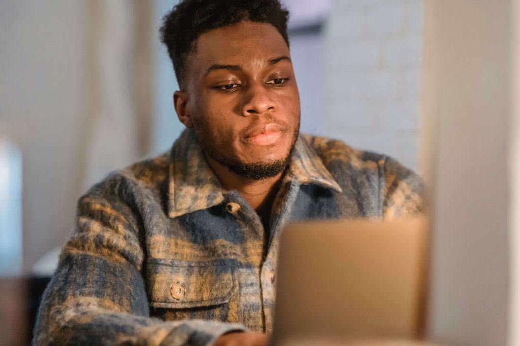 Man working on a laptop in a comfortable setting, illustrating the convenience of online therapy for men in Colorado Springs, CO.