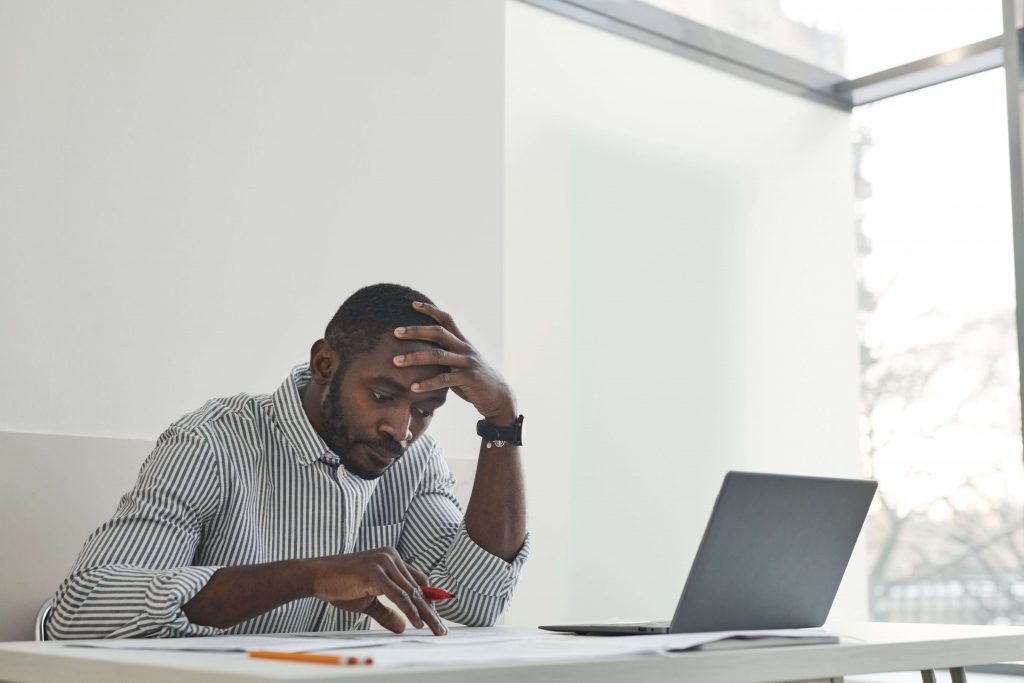 Man at work looking stressed, representing the impact of ongoing worry and pressure addressed through anxiety therapy for men in Colorado Springs, CO.