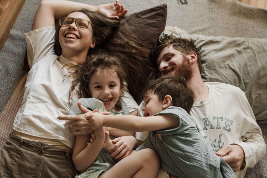 Healthier Family Relationships - therapist for men in colorado springs, co - counselor for men colorado springs co - mens therapy colorado springs, co Happy family with two parents and two children smiling together, symbolizing stronger connections, emotional well-being, and lasting growth supported by a therapist for men in Colorado Springs, CO.