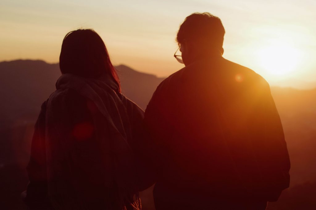 Couple sitting together during sunset, representing the disconnect and relationship struggles addressed through anxiety counseling for men in Colorado Springs, CO.