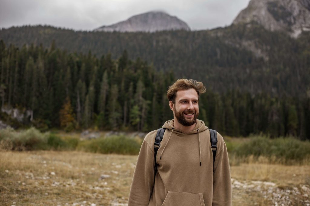 Smiling man outdoors with the Colorado mountains in the background, representing resilience, emotional healing, and renewed confidence supported through EMDR therapy for men in Colorado Springs, CO.
