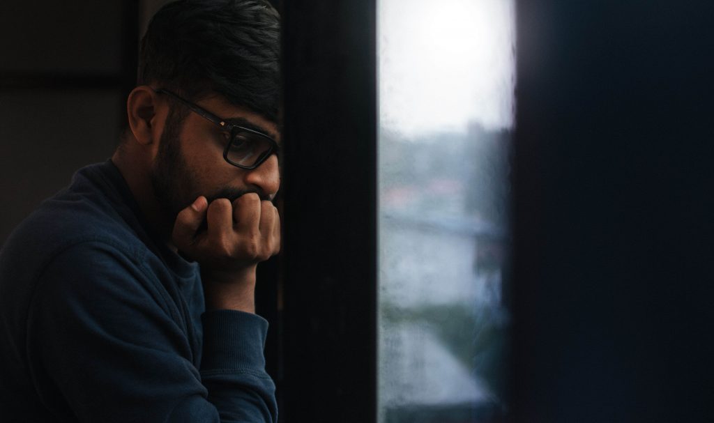 Man looking anxious, representing the persistent stress and racing thoughts addressed through anxiety therapy for men in Colorado Springs, CO.