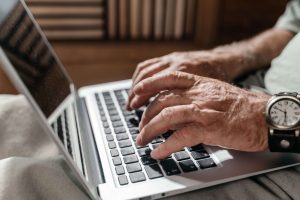 Man using a laptop, representing accessible emotional support and online therapy for men in Colorado Springs, CO.