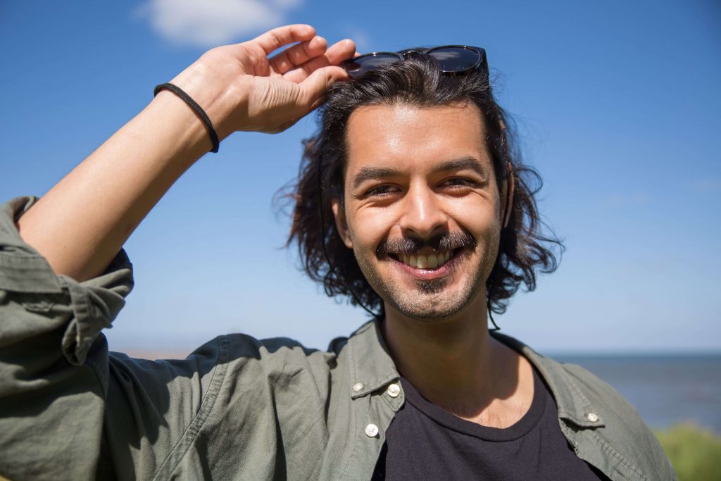 Happy man smiling, representing improved emotional well-being and personal growth supported through online therapy for men in Colorado Springs, CO.
