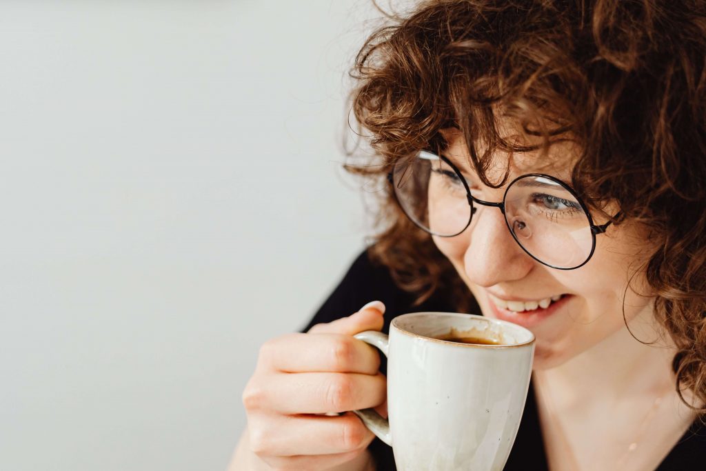 Finding Relief - depression therapist colorado springs co - depression therapy colorado springs co - depression counseling in colorado springs co - denver co Woman drinking coffee while appearing content, symbolizing improved well-being and emotional balance supported by a depression therapist in Colorado Springs, CO.