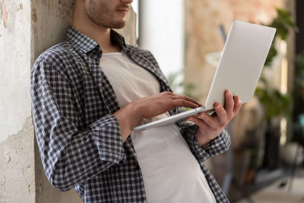 Man using a laptop, symbolizing flexibility and convenience for men seeking mental health support through online therapy in Colorado Springs, CO.