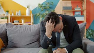 Sad and stressed man coping with difficult emotions after divorce and adjusting to life after marriage.
