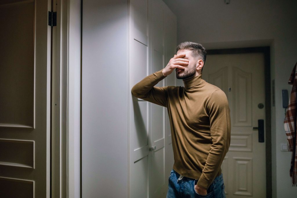Stressed man resting his hand on his face, representing the emotional challenges that may lead someone to seek therapy for divorce in Colorado Springs, CO.
